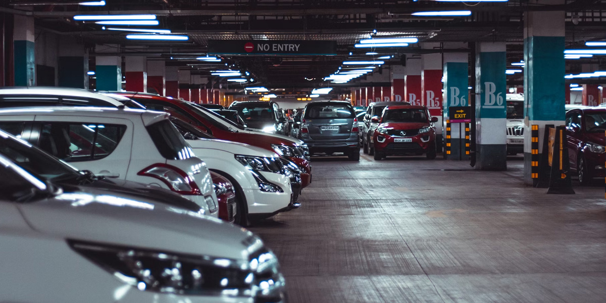 Close-up of parked cars in an indoor parking garage, focusing on the front row of vehicles.